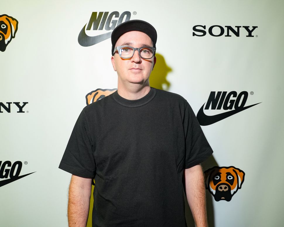 A man in a black shirt, glasses and a black baseball cap