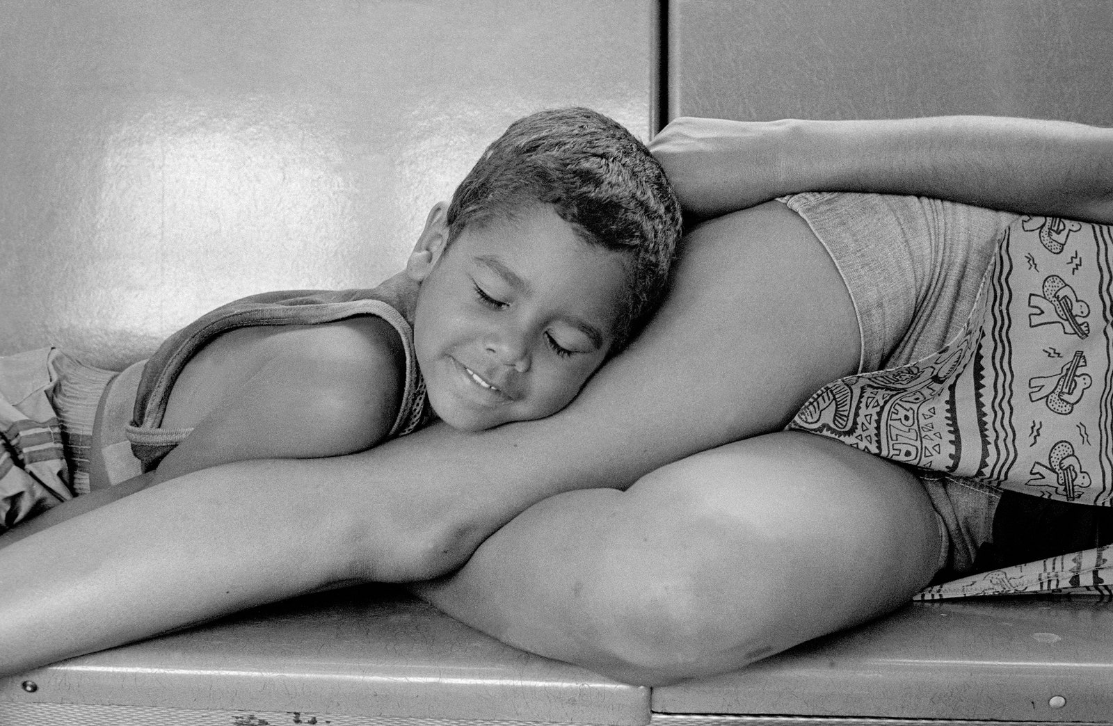 A boy laying on a woman's legs.