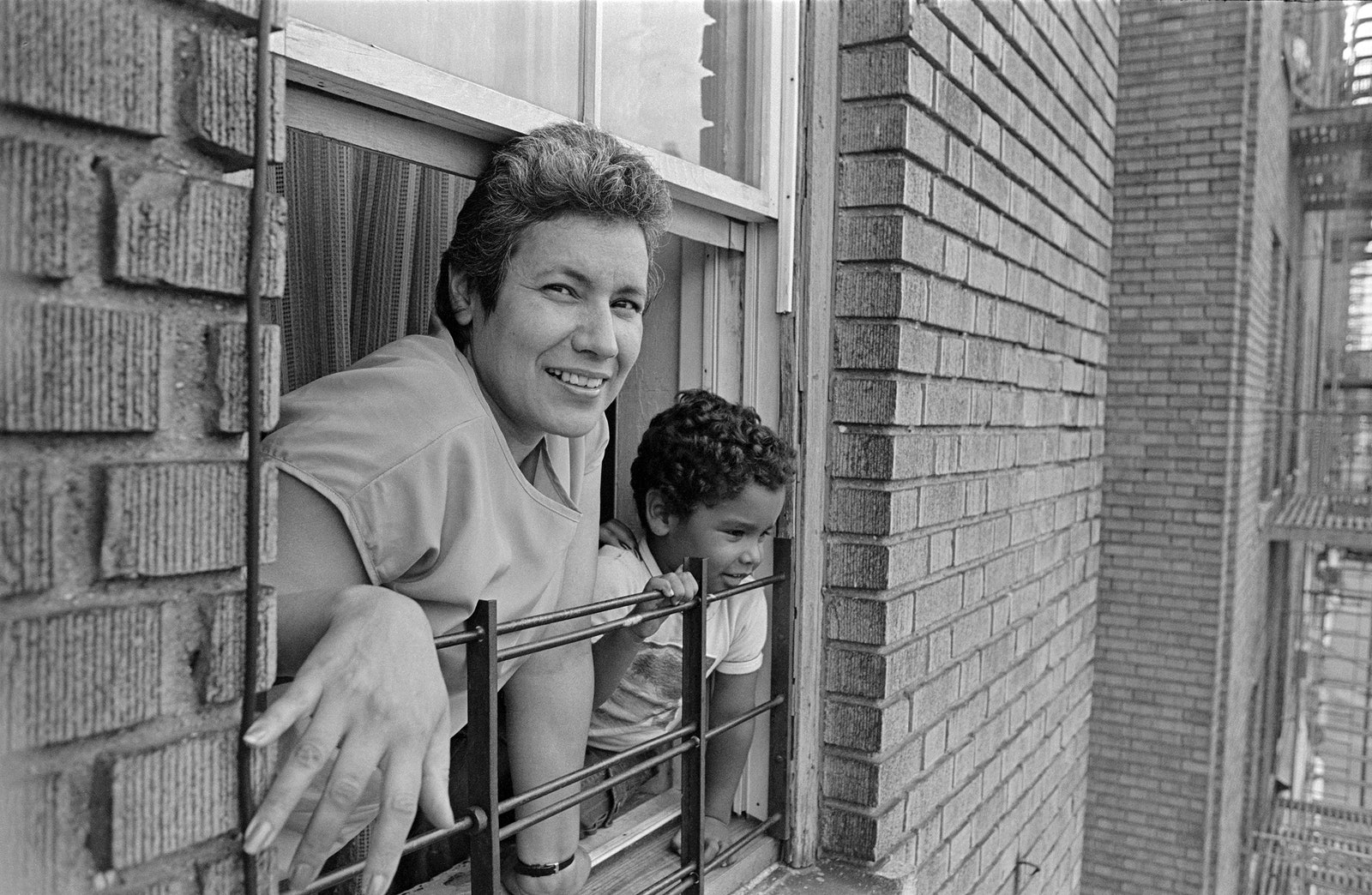 A woman and child looking out a window.