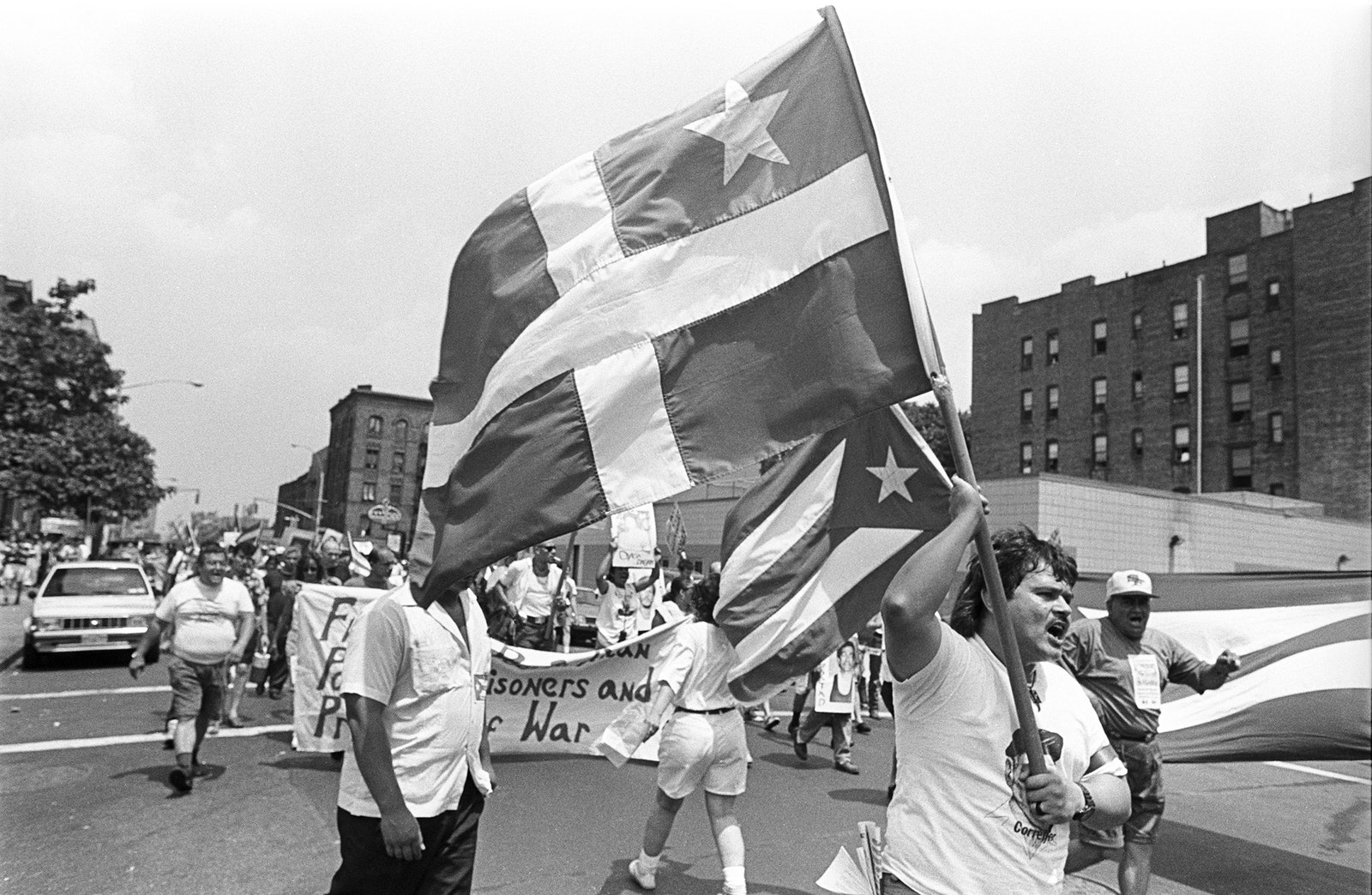 People marking down the street holding Puerto Rican flags.