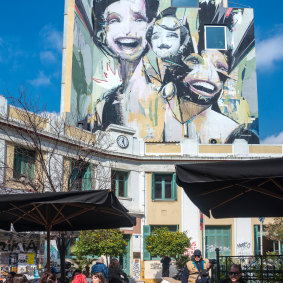 A street art mural looms over Iroon Square in the Psyrri district.