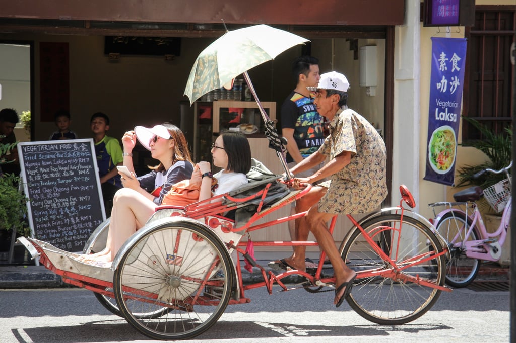 Penang’s distinctive trishaws still do a busy trade ferrying tourists around town. Photo: John Brunton