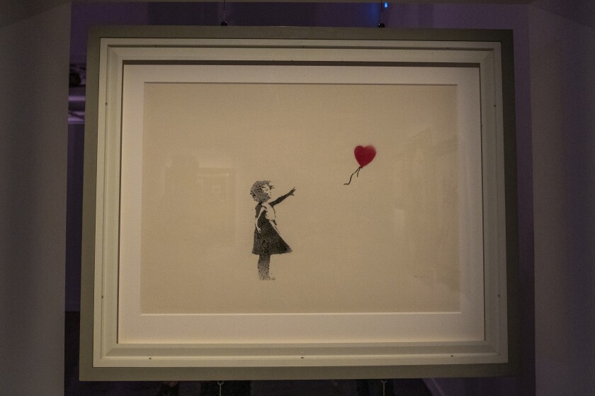 “Girl With Balloon” is among the 80 works by the mysterious English street artist known as Banksy, in the hugely anticipated exhibit “The Art of Banksy,” opening Saturday at 360 N. State. The original works are from private collections and rarely or never before seen by the public. The exhibit runs through Oct. 31. | Tyler LaRiviere/Sun-Times