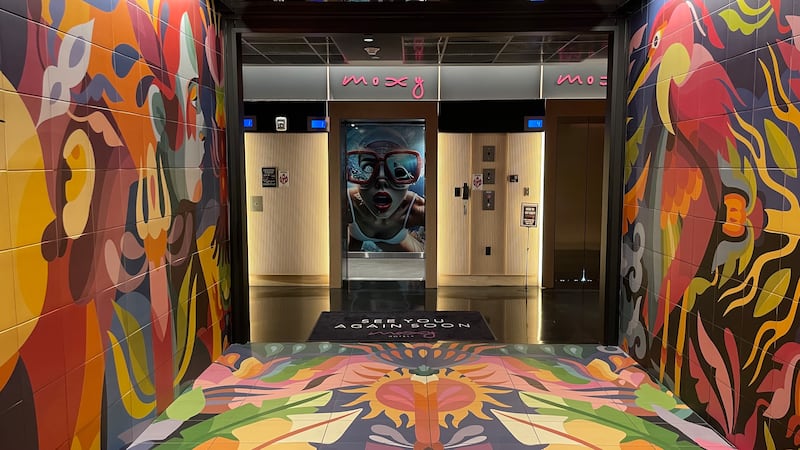 The colourful lobby of the Moxy Miami Wynwood which includes a picture in the lift of the same woman featured on a giant mural on the side of the building.