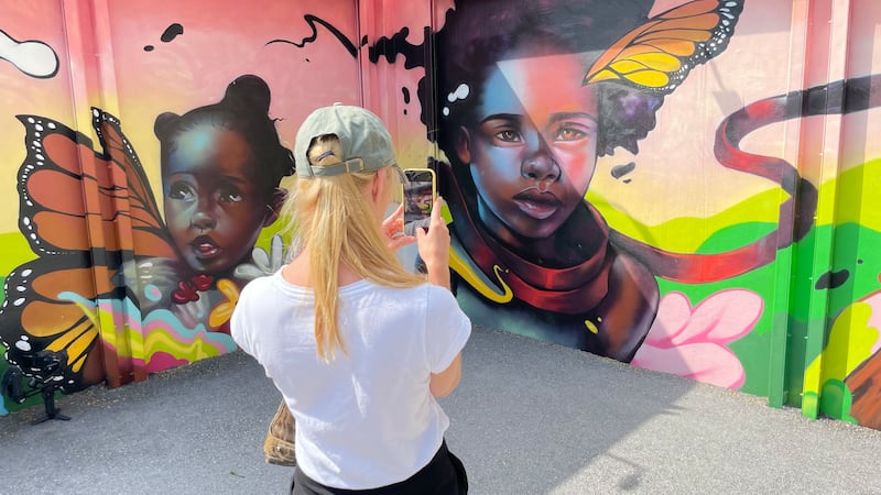 A visitor takes a photo of street art in the Wynwood Walls exhibition.