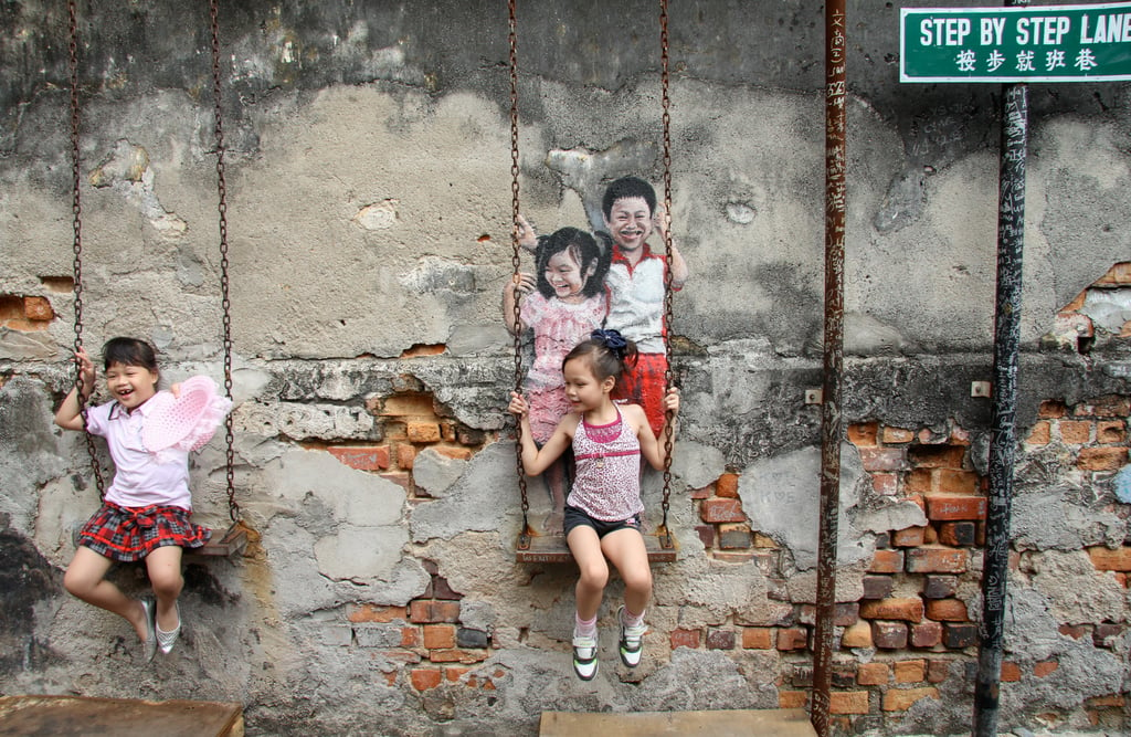 Children posing for parents in Step by Step Lane, with graffiti art by Lithuanian Ernest Zacharevic. Photo: John Brunton