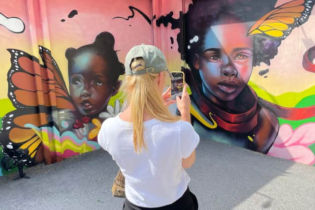 A visitor takes a photo of street art in the Wynwood Walls exhibition, Miami