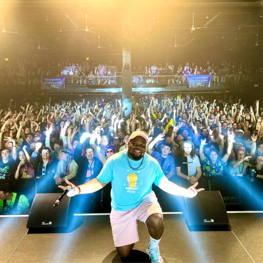 Austin Jones kneels onstage in front of a full crowd