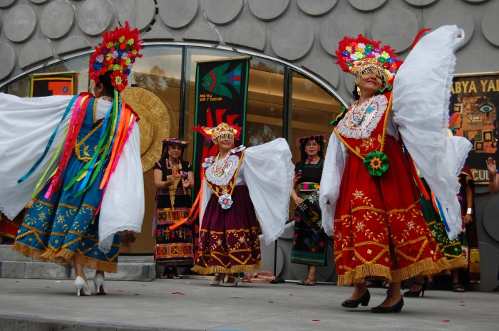 Dancers in vibrant costumes in the outdoor amphitheater at the Bronx Music Hall.