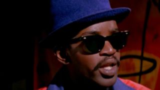 Fab Five Freddie wearing a blue hat and sunglasses in Wild Style