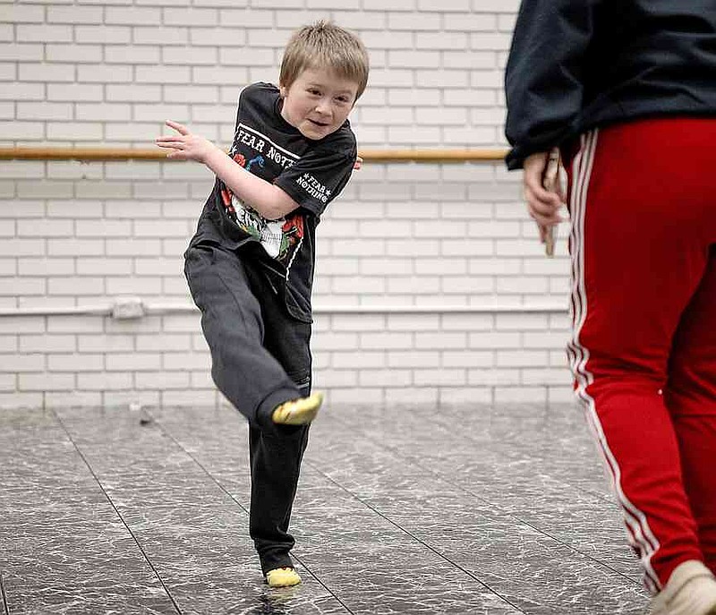 Matthew Cochran does a kick step during a dance class with Rooted Movement Collective on Wednesday, Jan. 29, 2025, at Harmony Leadership Academy in Texarkana, Ark. CeCe Marie, the Collective's artistic director, taught the students a motto before the class: