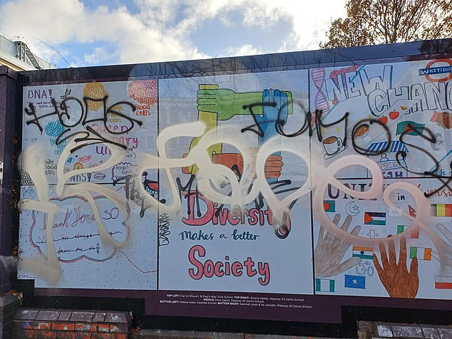 Turn right and walk a few yards and there is vandalised a mural, which appears to be designed by children, that says: 'Diversity makes a better society'