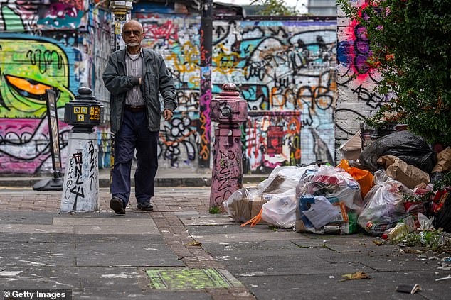 A man walks solemnly past as not a single plain brick is visible