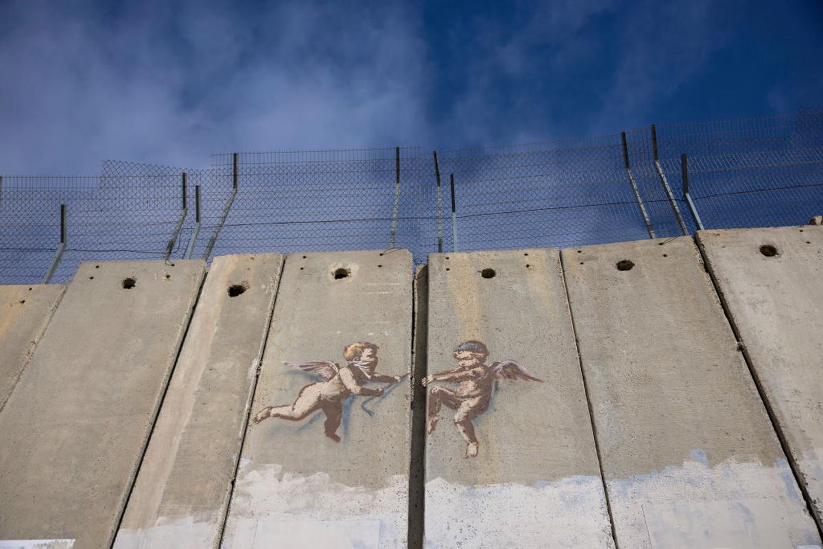 A 2017 Banksy mural shows cherubs prying open the separation barrier in Bethlehem, West Bank, opposite the Walled Off Hotel.