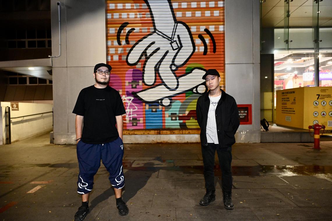 ANTZ (left) and Glenn “Goris” Ong in front of their mural ‘working hands NOW and THEN’