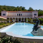 A villa with a large fountain at its center.