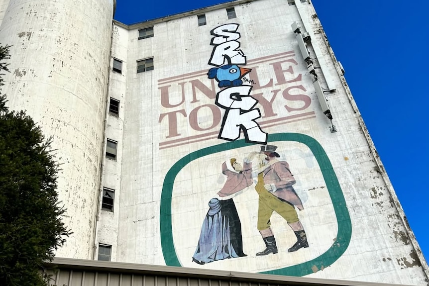 Graffiti on top of a historic Uncle Tobys advertisement on the side of a factory in Footscray.