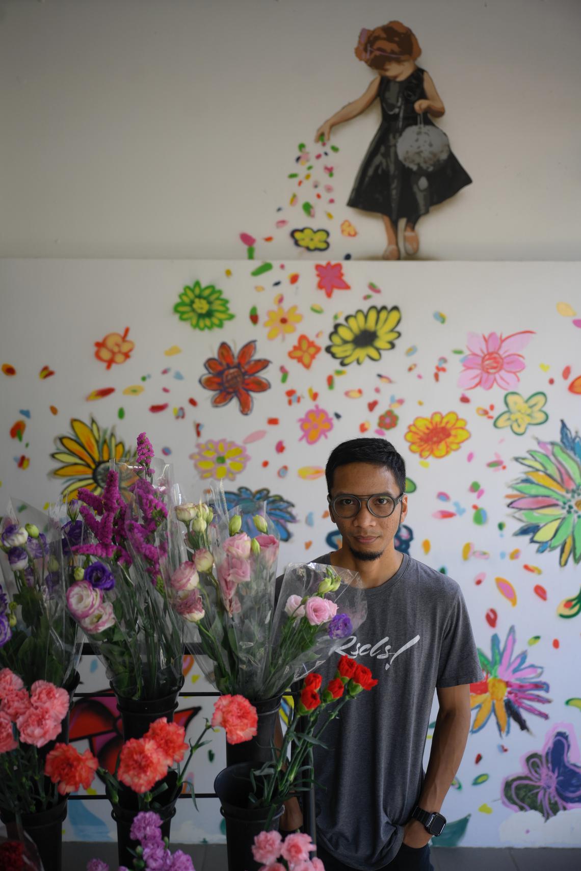 Street artist Sufian Hamri, also known as TraseOne, pictured with a mural which he did with Queenstown residents at Mei Ling Market and Food Centre on Feb 4, 2025.