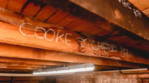 Broadleaf Partnership Trust A large wooden beam on a roof with the words 