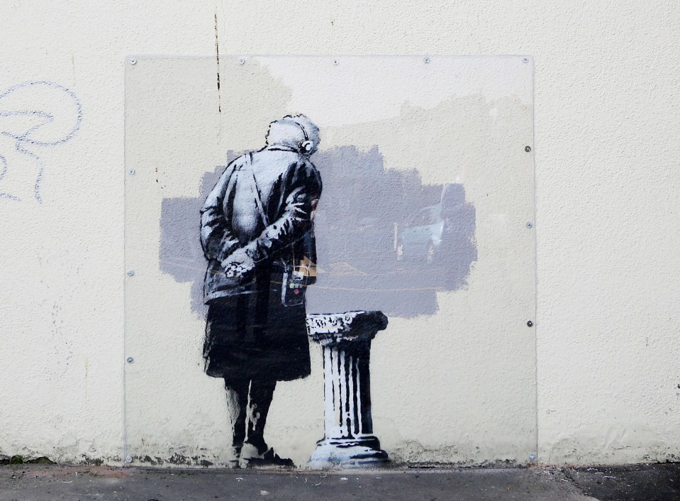 Banksy mural of a woman looking at a blurred street scene.