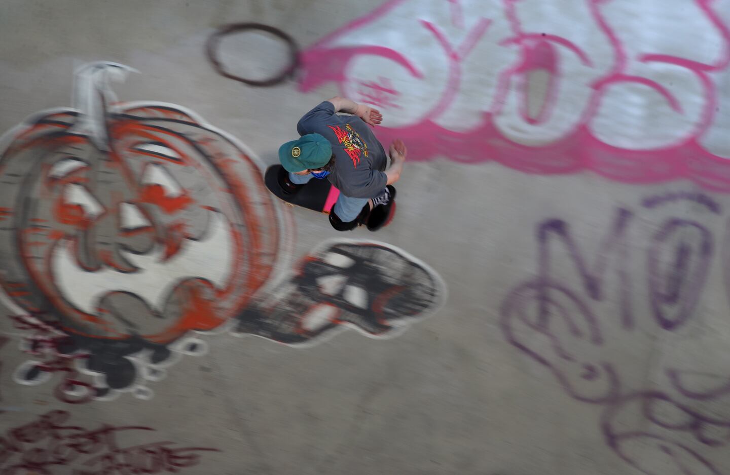 A skateboarder rides over grafitti at the park in 2020.