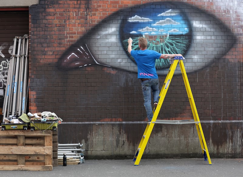 Artists on Talbot street as part of the Belfast Street Art festival. PICTURE COLM LENAGHAN