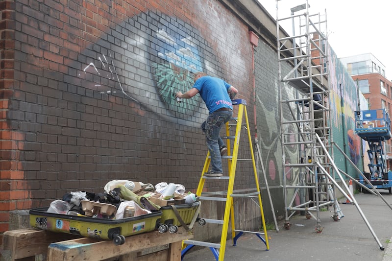 Artists on Talbot street as part of the Belfast Street Art festival. PICTURE COLM LENAGHAN