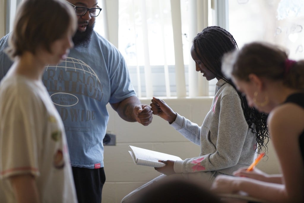 Trevon Hobson fist bumps student Kenny Agasayo.