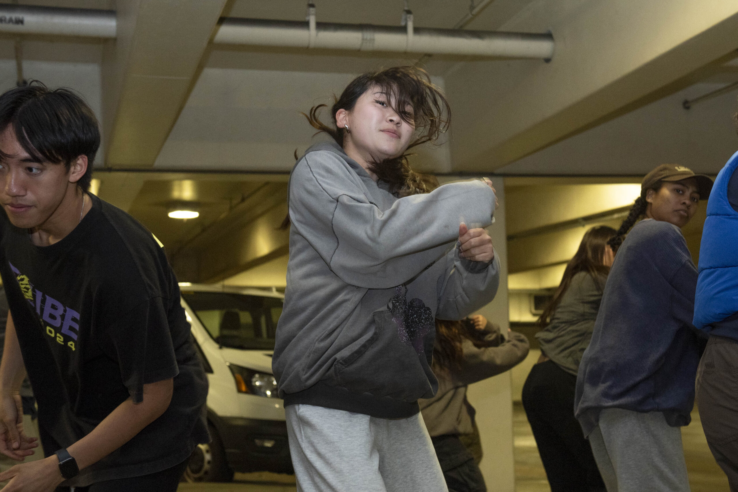 Members of ACA All Day dance in a parking garage while swinging their arms and popping their shoulders. The group's Spring Sing set will be accompanied by music such as Doechii and JT's “Alter Ego” and Earth, Wind & Fire and The Emotions' “Boogie Wonderland.” (Leydi Cris Cobo Cordon/Daily Bruin senior staff)