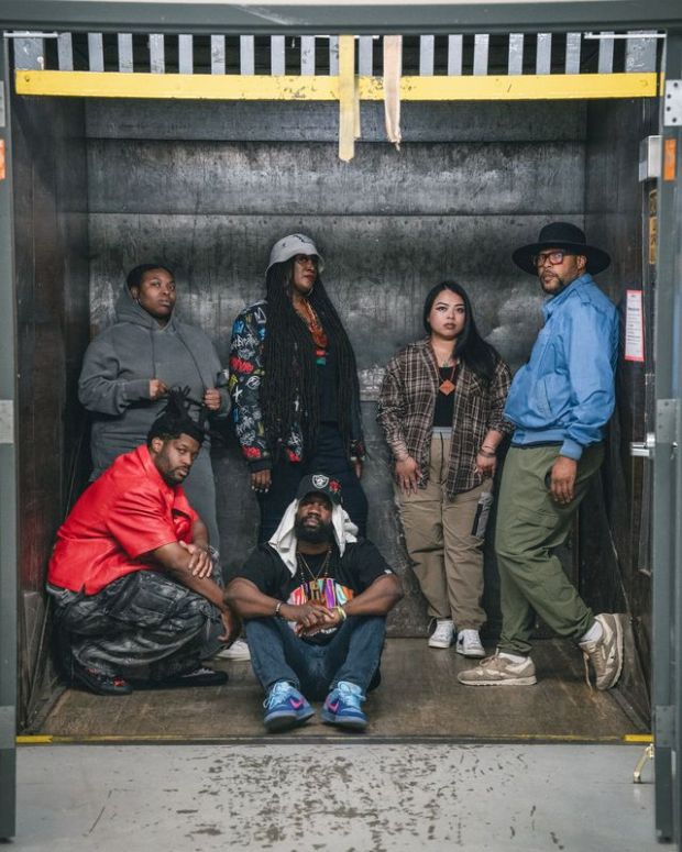 Six people pose in a loading dock.